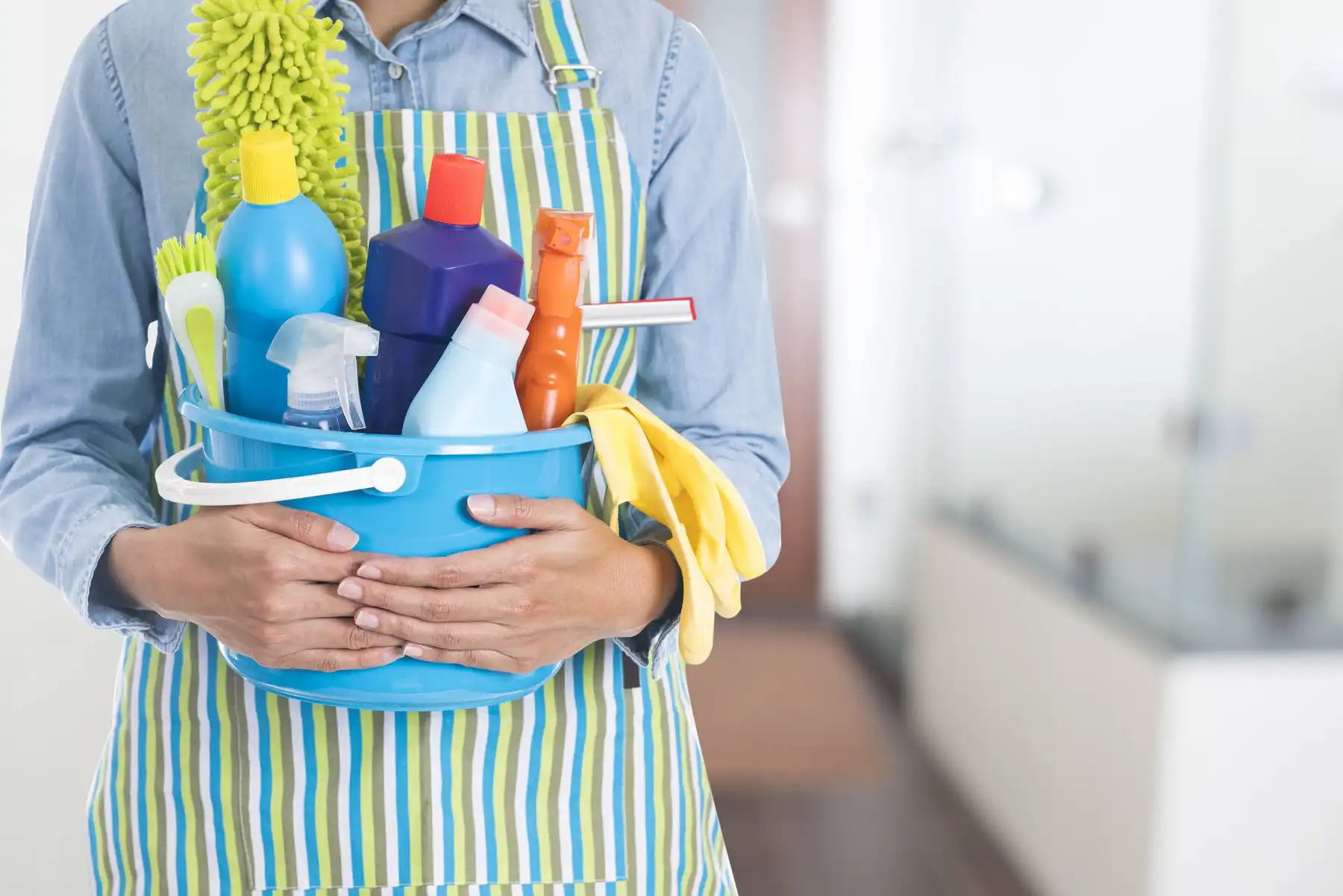 hình ảnh một người ôm chậu để các chất tẩy rửa chuyên dụng khi dọn dẹp nhà cửa 